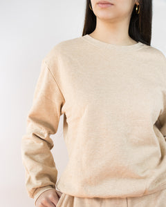 Una mujer usando una polera de algodón color beige